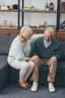 © LIGHTFIELD STUDIOS - senior woman sitting near retired husband and holding hands in living room
