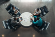© JonoErasmus - Group of African business people sitting and discussing statistics during a sit down meeting taking from above
