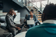 © JonoErasmus - Two friendly African buiness people in a meeting chatting casually