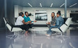 © JonoErasmus - Team of african bussines people sitting in a modern office and talking during an work meeting