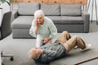 © LIGHTFIELD STUDIOS - senior woman helping to husband who falled down on floor