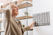 © LIGHTFIELD STUDIOS - senior man touching wall calendar and head
