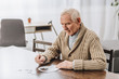 © LIGHTFIELD STUDIOS - pensioner with grey hair playing with puzzles at home