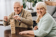 © LIGHTFIELD STUDIOS - happy pensioners playing jenga game on table