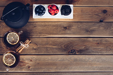 Poster - Flat lay of Cup of te and iron with dried fruit tea, cinnamon and fruits of the forest. vintage style