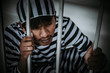 © reewungjunerr - Portrait of Asian men desperate to catch the iron prison,prisoner concept,thailand people,Hope to be free.