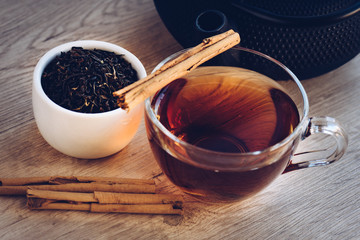 Wall Mural - Cup of tea and kettle, iron, dry leaves and cinnamon