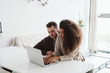 © ADDICTIVE STOCK - Cheerful multiethnic couple using laptop together