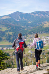 Wall Mural - couple hiking in the mountain and enjoying view on the lake