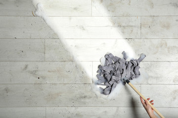 Woman cleaning wooden floor with mop, top view. Space for text