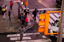 (focus On The Traffic Light) Close-up View Of A Traffic Light And Blurred People In The Background Crossing The Street In Times Square, New York City, United States.
