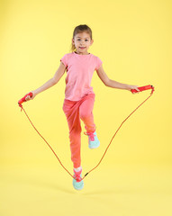 Sticker - Full length portrait of girl jumping rope on color background