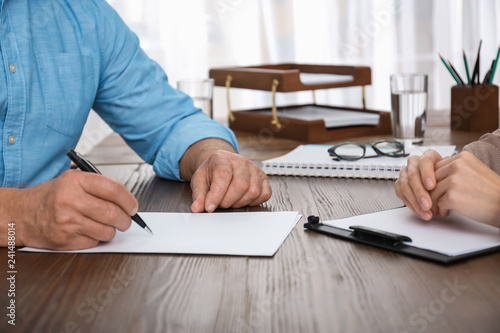 Fotografía Senior man signing document in lawyer's office