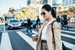 © PR Image Factory - Stylish asian woman walking on crosswalk.