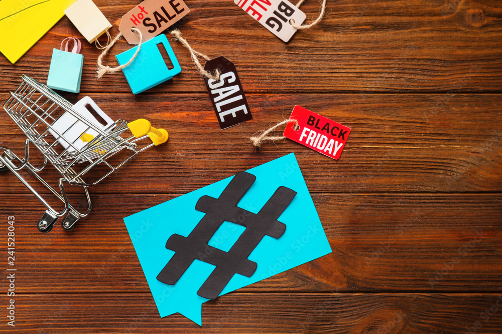 Composition with shopping cart and hashtag sign on wooden background