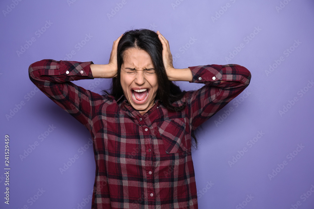 Screaming young woman on color background