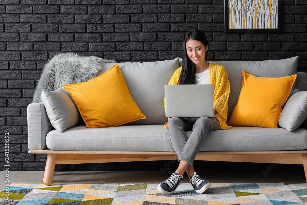 Young Asian woman studying with laptop at home