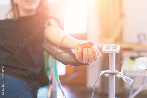 Fotografía young woman as blood donor at donation with a bouncy ball holding in hand