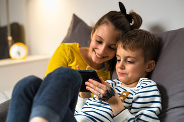 brother and sister using tablet together at home