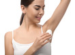 © Pixel-Shot - Young woman using deodorant on white background