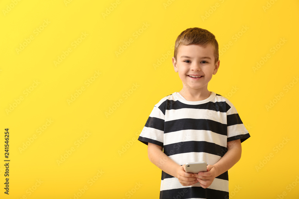 Cute little boy with smartphone on color background