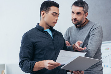 Wall Mural - businessmen holding folder with papers and discussing project in office