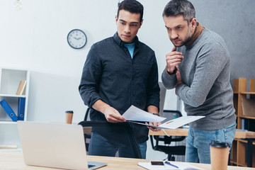 Wall Mural - serious professional businessmen working with papers and looking at laptop in office