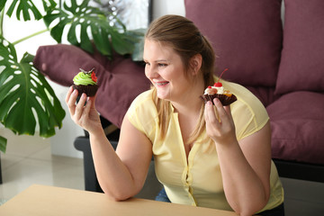 Wall Mural - Beautiful plus size girl with sweet cakes at home. Concept of body positivity