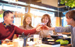 © Tom Wang - happy young people friends toasting and eating in the restaurant