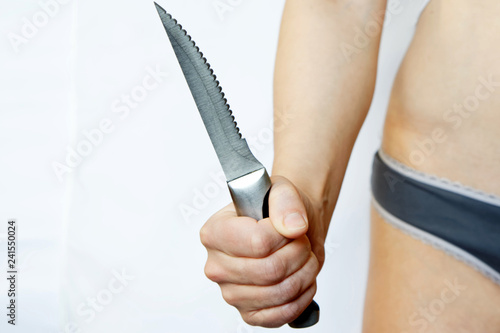 Fotografia, Obraz Female hand holding a steel knife on a white background