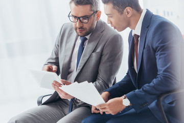 Wall Mural - focused businessmen working with papers and digital tablet in office