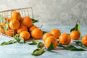 Overturned basket with tasty juicy tangerines on light table