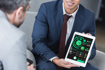 Wall Mural - cropped shot of young businessman showing digital tablet with business charts to colleague