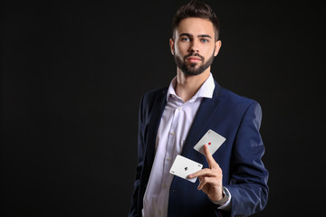 Wall Mural - Handsome young man with cards on dark background