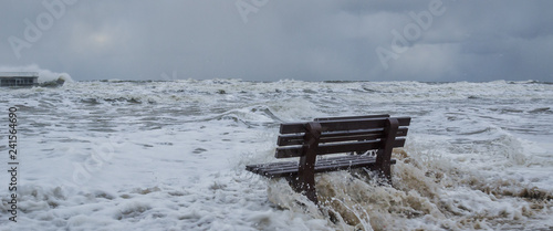 Cuadros en Lienzo STORM AT SEA - A bench flooded by storm waves on a sea beach in Kolobrzeg