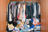Fototapeta Paryż - Pile of messy clothes in closet. Untidy cluttered woman wardrobe.