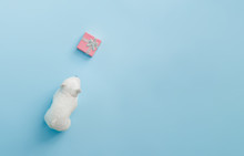 Polar Bear Toy With Christmas Gift Box On Bright Pastel Blue Background. Christmas And Winter Holidays Concept.