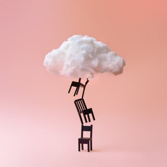 Wall Mural - Stacked chairs with cloud against coral color background. Minimal success concept background.