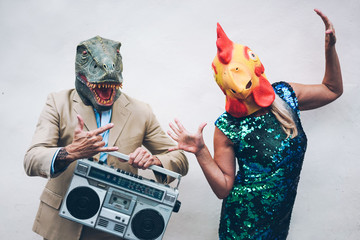 Wall Mural - crazy senior couple dancing for new year's eve party wearing t-rex and chicken mask