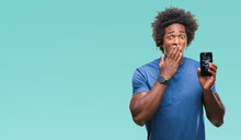 Afro American Man Holding Broken Smartphone Over Isolated Background Cover Mouth With Hand Shocked With Shame For Mistake, Expression Of Fear, Scared In Silence, Secret Concept