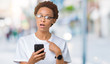 © Krakenimages.com - Young african american woman using smartphone over isolated background with surprise face pointing finger to himself