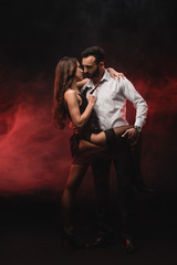 Wall Mural - passionate loving couple hugging in red smoky room