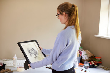 Wall Mural - Female Teenage Artist Holding Framed Charcoal Drawing Of Dog In Studio