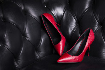 Two red leather shoes on a dark background. Women's fashionable high-heeled shoes.