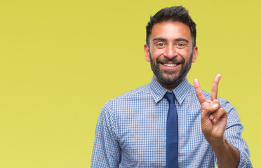 Adult hispanic business man over isolated background smiling with happy face winking at the camera doing victory sign. Number two.