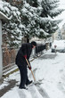 © Coka - man clean snow on street in front house with shovel cold winter day