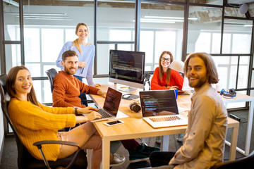 portrait of a group of young programmers dressed casually working on computer code sitting in the mo