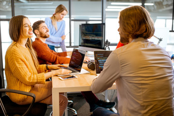 team of a young programmers dressed casually working on computer code sitting in the modern office i