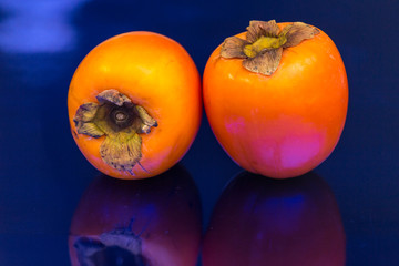 kakis on blue background, fleshy fruits