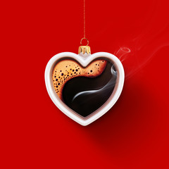 Christmas toy is made from a fragrant cup of coffee. Christmas toy. Holiday concept. Cup in the shape of a heart on a red background for your design. Advertising coffee.